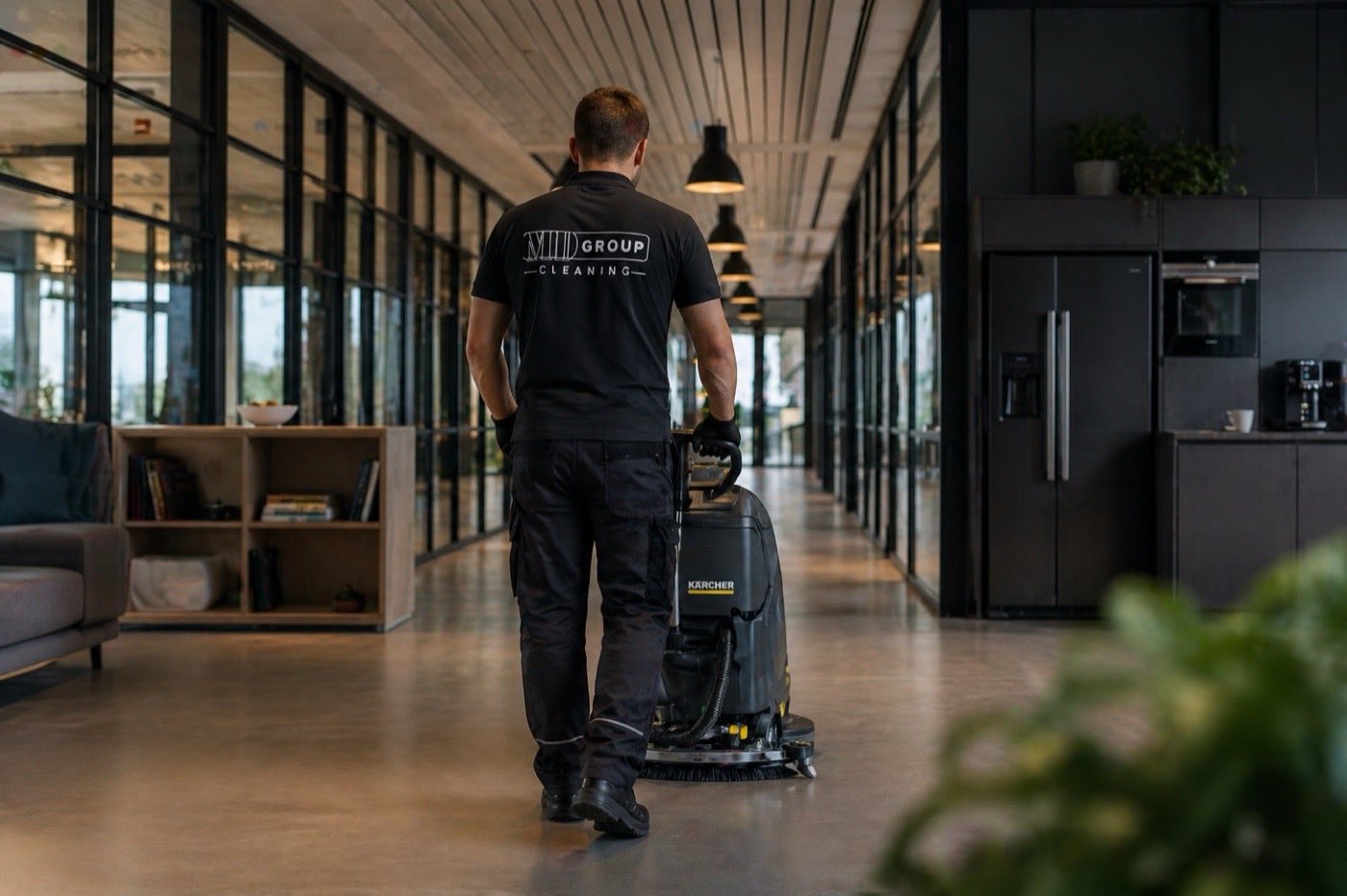 Pracownik MD Group Cleaning z profesjonalna maszyna szorujaca w nowoczesnym biurze